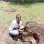 An image of Bikoro with a loquat tree seedling in hand ready for planting
