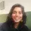 Female, indian origin, wearing blue jumper, yellow earrings, hair down